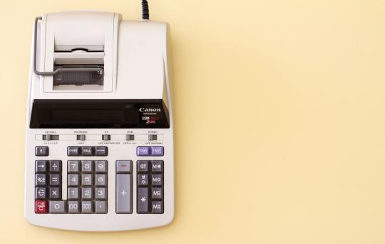 foto van oude rekenmachine op gele achtergrond 